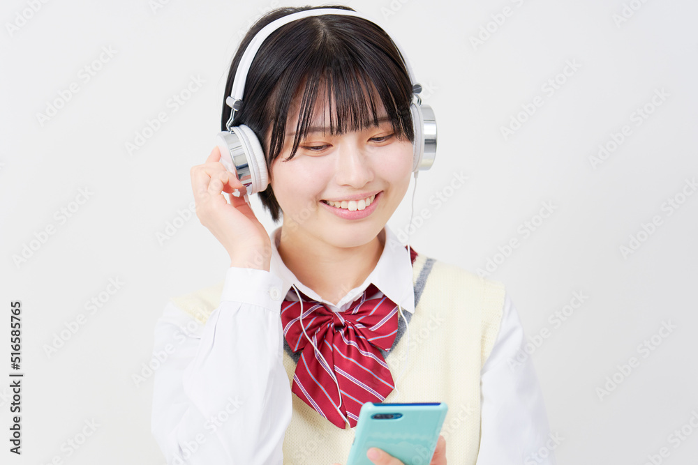 ヘッドフォンで音楽を聴く女子高生 白背景 ヘッドフォンで音楽を聴く女子高生 白背景
