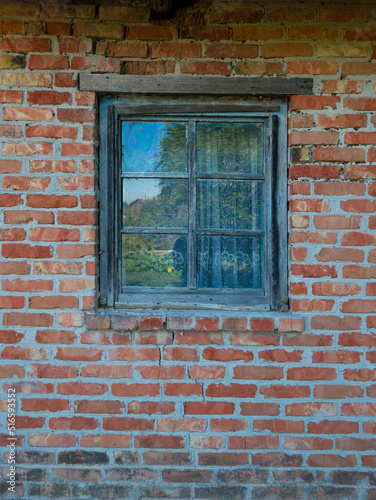 a glass window with a wooden frame is installed in a brick house