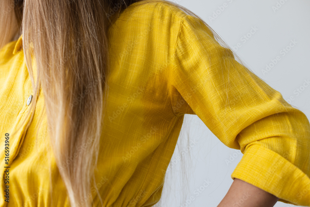 Fototapeta premium Woman in yellow dress with wet armpits. Closeup.