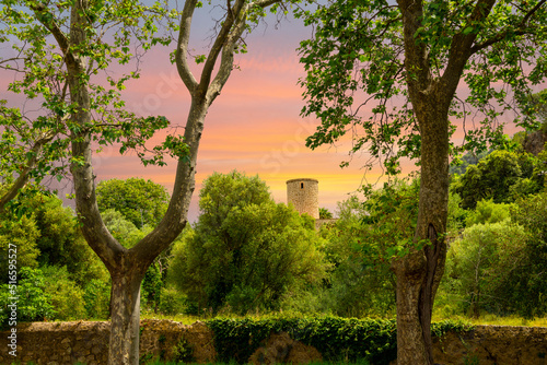 Sunset view under a colorful sky of a round tower of the Jardins Rei Joan Carles, a public garden in the picturesque historic village of Valldemossa on the Balearic island of Mallorca, Spain. photo