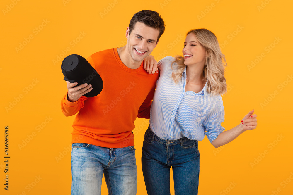 Obraz premium attractive stylish young couple holding wireless speaker