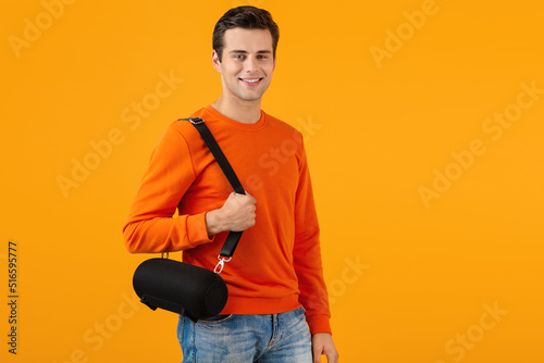 stylish young man holding wireless speaker