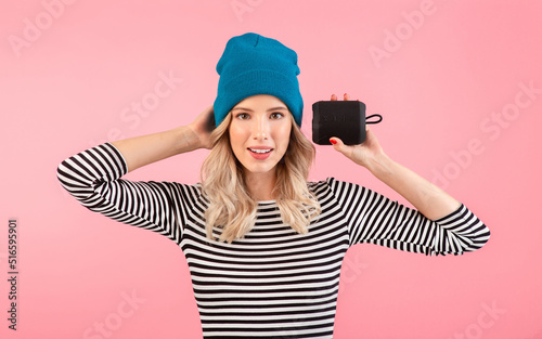 young woman holding music speaker