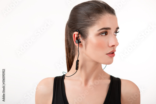 attractive woman in jogging black top listening to music on earphones