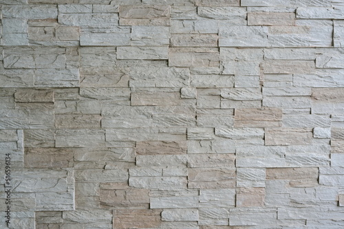 The walls for vintage style are decorated with uneven beige embossed narrow granite tiles. old brown brick wall There are natural patterns on that brick. seamless surface uneven surface background 