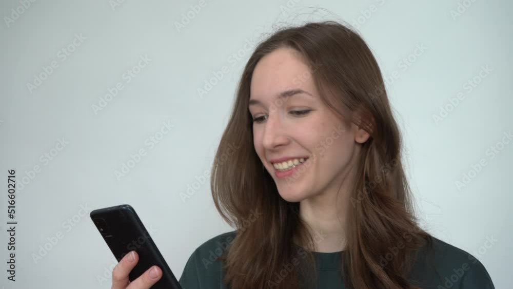 A young woman emotionally reading messages on her smartphone A young woman emotionally reading messages on her smartphone
