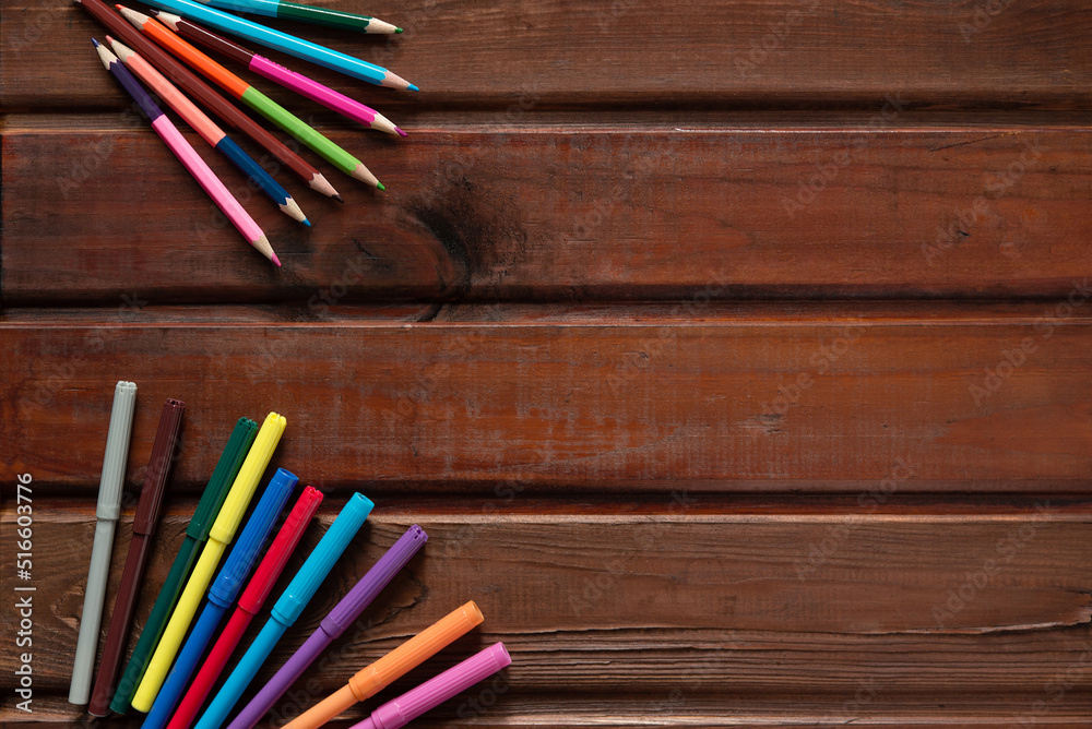 Obraz premium school stationery with markers and other supplies on brown wooden background. back to school concept