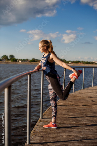 Slim fit woman doing stretching exercises on pier at sunny day © rostyslav84