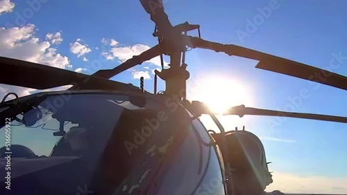 A close-up view of the coaxial rotors of a military helicopter as they spin before takeoff - seamless looping. photo