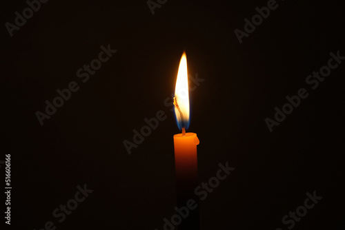 Brennende Kerze in schwarzem Hintergrund
