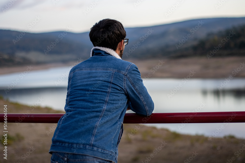 portrait of an unrecognizable young man with glasses with his back turned contemplating the landscape portrait of an unrecognizable young man with glasses with his back turned contemplating the landscape