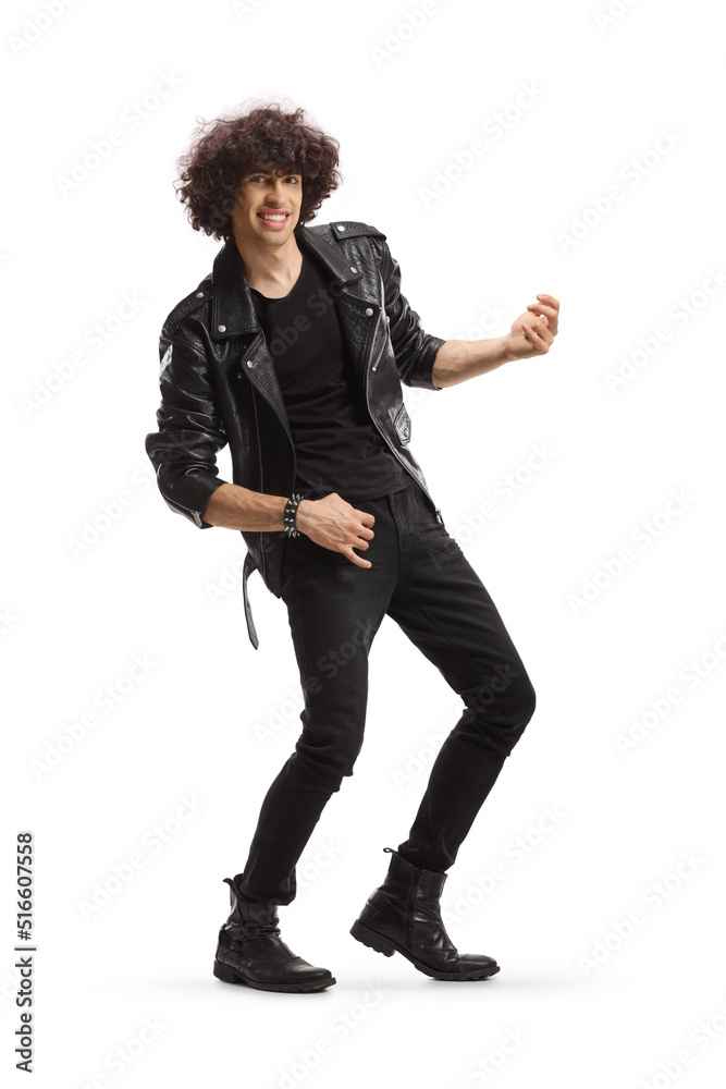 Cheerful young man in a leather jacket pretending to play a guitar Cheerful young man in a leather jacket pretending to play a guitar