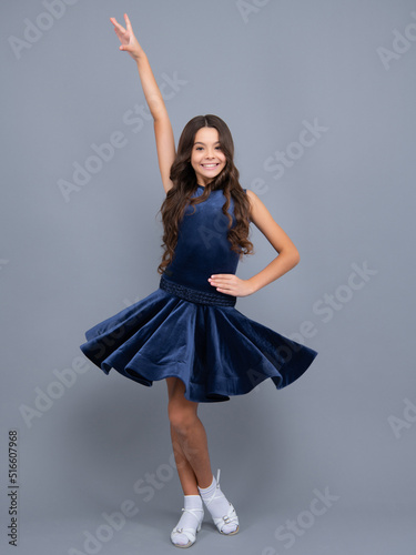 Ballroom teenager dancer isolated on studio grey background. Latin classic dance. Rumba, samba dancing pose. Ballroom dance school for teenager kids girl. Dress movement.