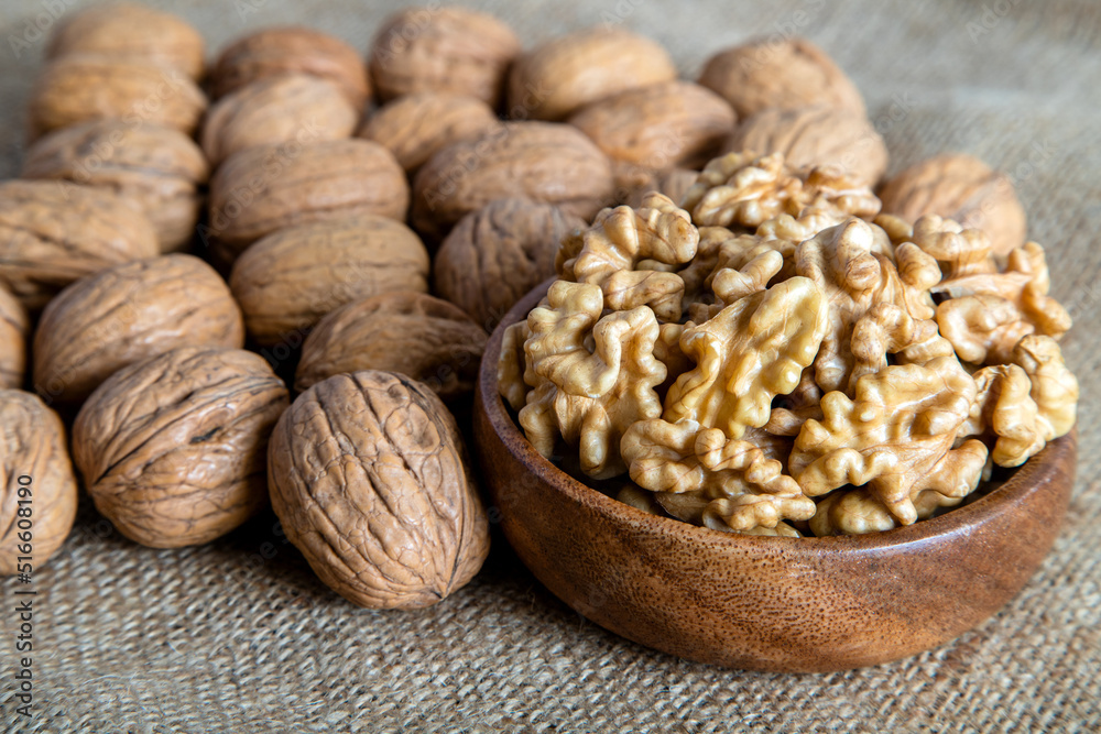 Peeled walnuts and whole walnuts on burlap sack Peeled walnuts and whole walnuts on burlap sack