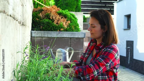 A female farmer tending a blooming vertical garden on a summer day. Ideas for vertical gardening of landscape design. High quality 4k footage