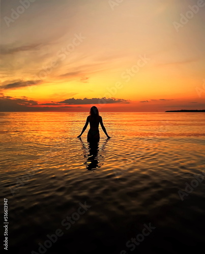 women on orange sunset at sea nature background  © Aleksandr
