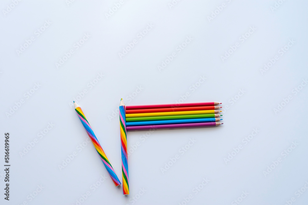 Fototapeta premium Pride concept with rainbow pencils laid out in the Pride flag on white background.
