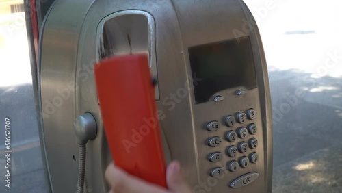 Classic telephone with a receiver on a cordphone.The person dials the number from the numeric keypad of a classic telephone with a handset. Calling from an old telephone  from public phone.

