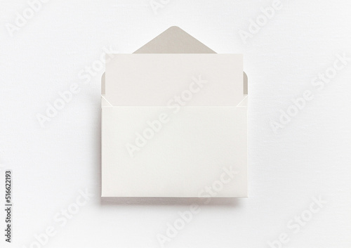 Mock up, blank white greeting card or invitation card and envelope, flat lay, top.