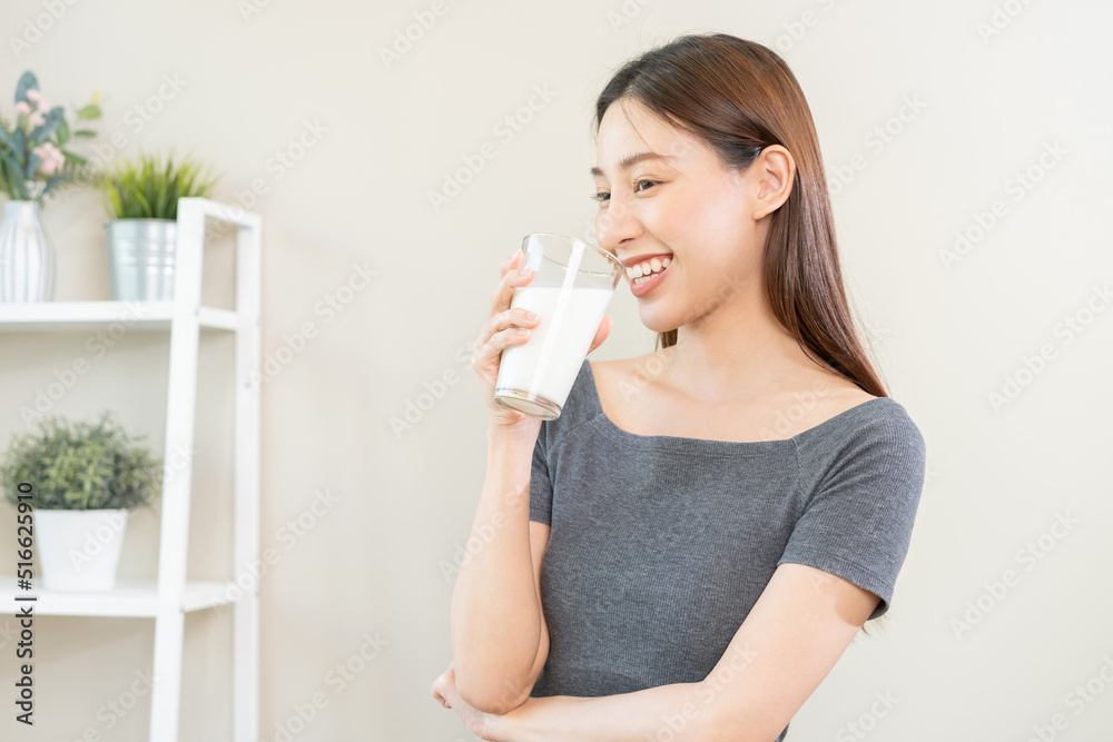 Happy, asian young woman, girl drinking a glass of white fresh, warm or hot dairy milk for calcium, vitamin wholesome good nutrition in morning. lifestyle, product healthy people, Isolated background. Happy, asian young woman, girl drinking a glass of white fresh, warm or hot dairy milk for calcium, vitamin wholesome good nutrition in morning. lifestyle, product healthy people, Isolated background.