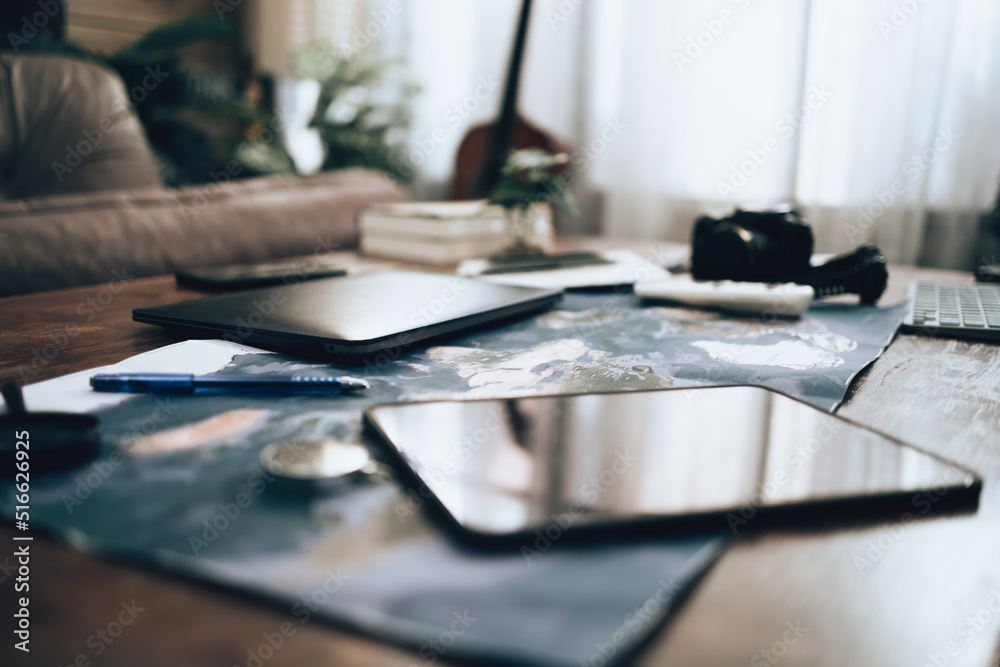 Fototapeta premium World map on the table. Laptop, tablet, camera, campass, pen and Tool of travel plan.