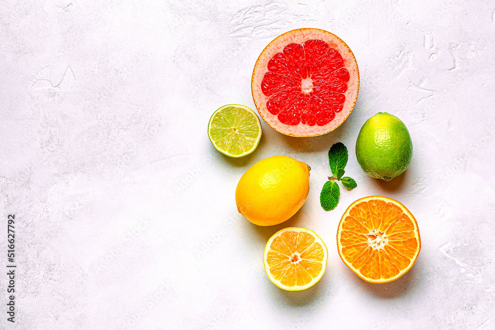 Fresh lemon, orange, grapefruit, lime, green leaves on light background, top view. Fresh lemon, orange, grapefruit, lime, green leaves on light background, top view.