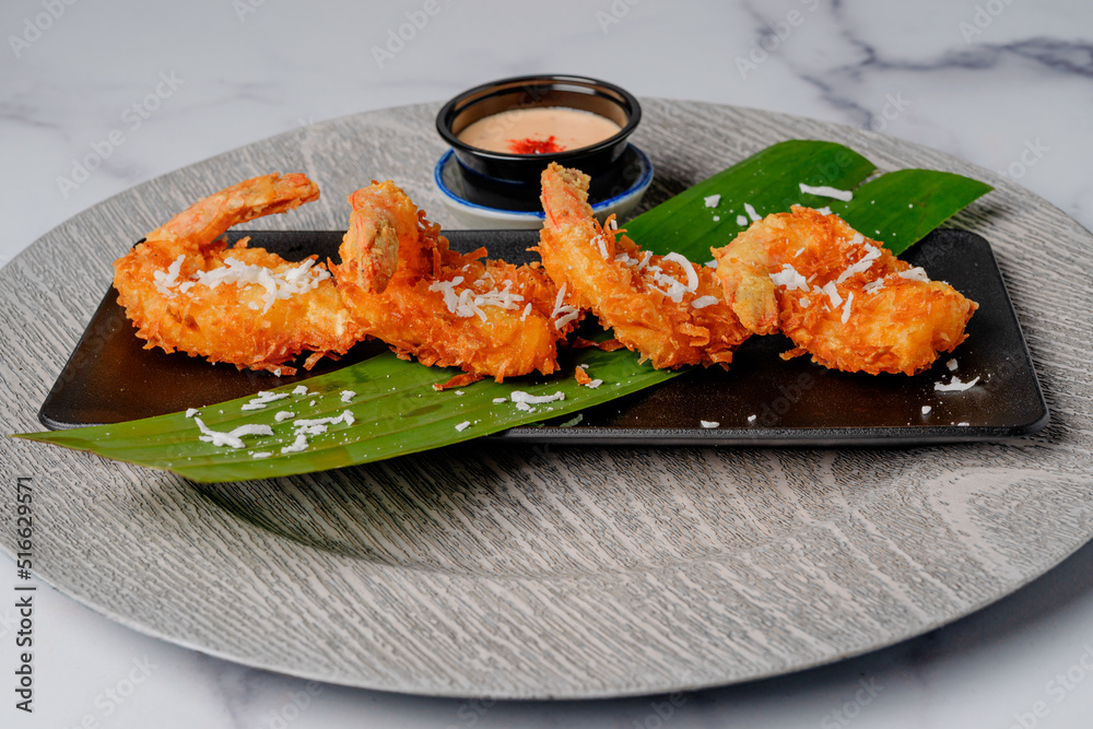 Fried coconut shrimp served with cocktail sauce close up Fried coconut shrimp served with cocktail sauce close up