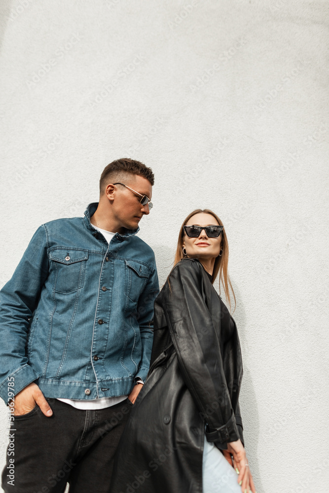 Fashionable happy beautiful couple in fashion denim casual clothes on the street. Stylish smiling woman and handsome trendy man Fashionable happy beautiful couple in fashion denim casual clothes on the street. Stylish smiling woman and handsome trendy man
