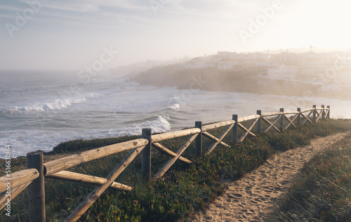 Amazing landscape of Atlantic ocean at sunrise. View on morning fog, big waves and stony coast. Beach of Praia das Macas. Colares. Portugal. Concept travel of Europe. 
