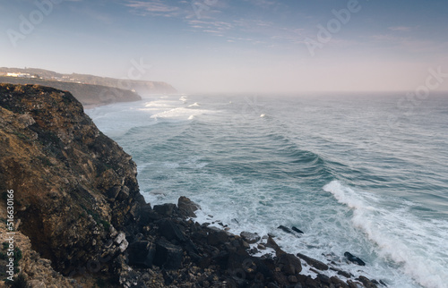 Amazing landscape on the Atlantic ocean at morning. View of the steep slopes of the rocky coast and the foam waves of the ocean. Beach of Praia das Macas. Portugal. Concept travel of Europe. © vovik_mar