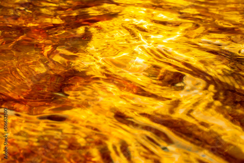 Amber and golden current in a wavy liquid