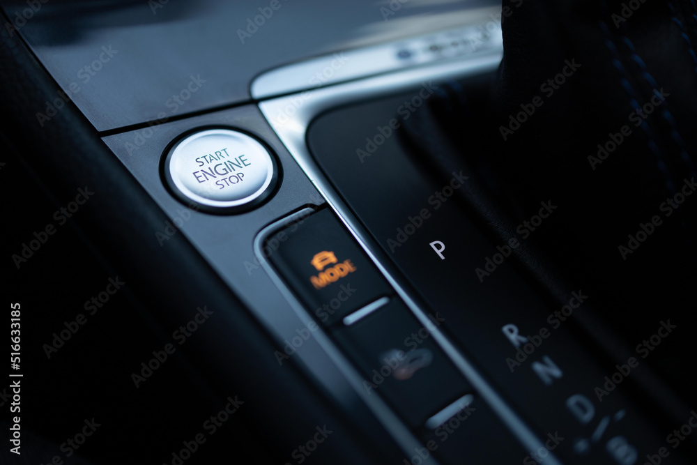 Start-stop buttons on modern cars selective focus. Silver start and stop button. Automatic electric car