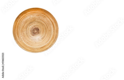 A photography of textured surface of light wooden round plate. White wall as a background of picture of natural materials with structural lack worn wholes, ugly dirty cracked rustic craft stile. photo