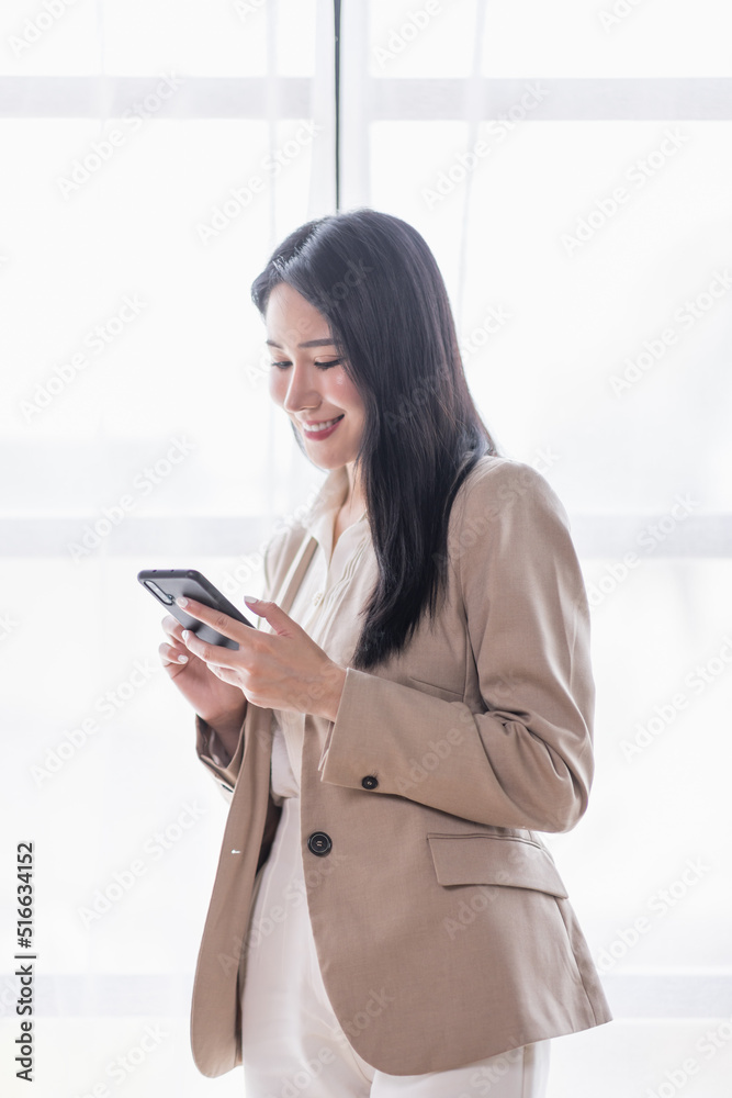 Portrait of Asian business woman using mobile phone application and pointing finger to smartphone isolated over white background. Portrait of Asian business woman using mobile phone application and pointing finger to smartphone isolated over white background.
