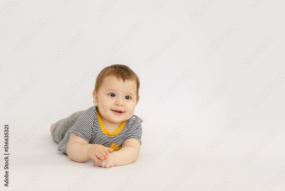 portrait of toddler, one year old baby boy lying on white background copy space. cute happy boy smiling lies portrait of toddler, one year old baby boy lying on white background copy space. cute happy boy smiling lies