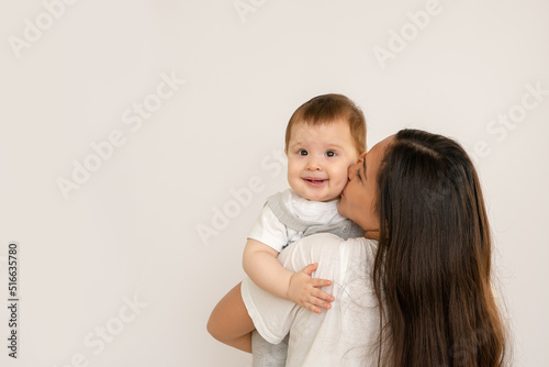 Happy young mother with her baby, little son in love on white background copy space. The concept of a happy family, motherhood. mother and child portrait