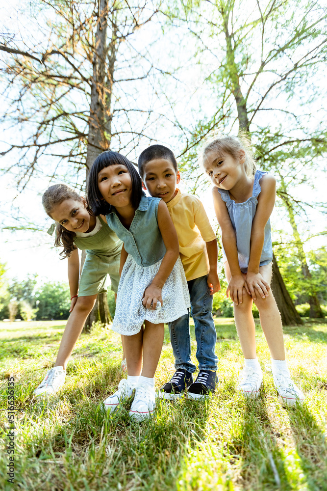Obraz premium Group of asian and caucasian kids having fun in the park