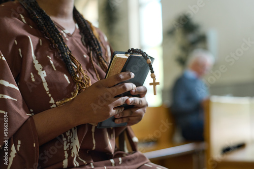 Tela Hands of young black woman with Holy Bible and rosary beads with small wooden cr