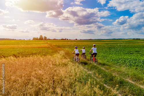 family on bike ride outdoors at sunset. mother and kids on bikes cycling outdoors. active family sport and fitness together. drone photo © drotik