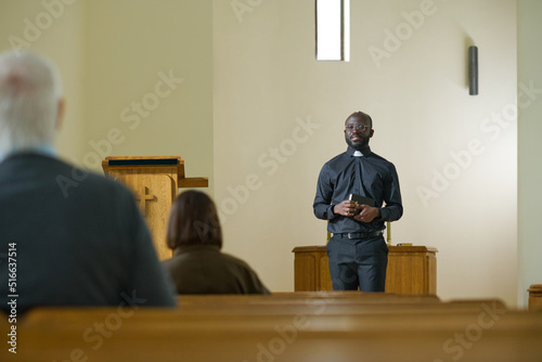 Tableau sur toile Young black man in priest apparel with clerical collar standing in front of pari