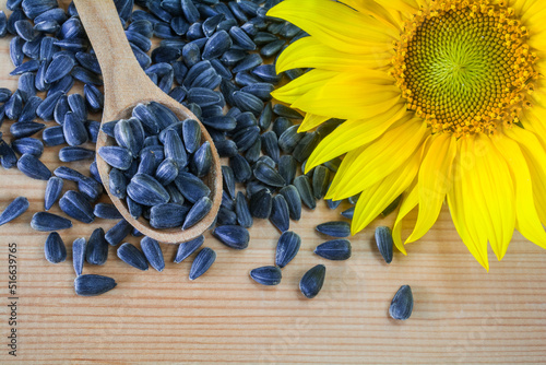 Sunflower seeds in a wooden spoon on a wooden background