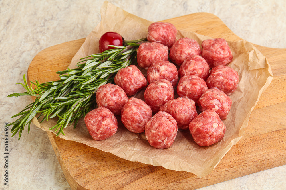 Raw uncooked beef meatballs served rosemary Raw uncooked beef meatballs served rosemary