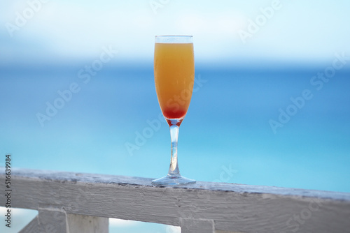  Delicious fruit cocktail with tequila on tropical beach. Ocean on background.