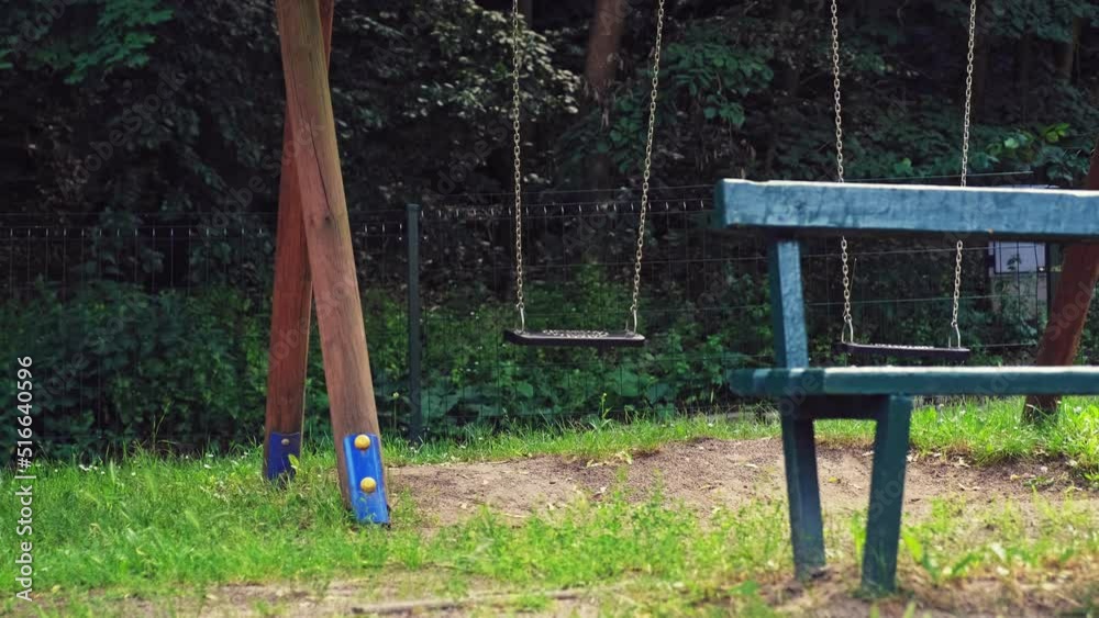 Empty Playground Swings With Plastic Seats Hanging on Metal Chain Empty Playground Swings With Plastic Seats Hanging on Metal Chain