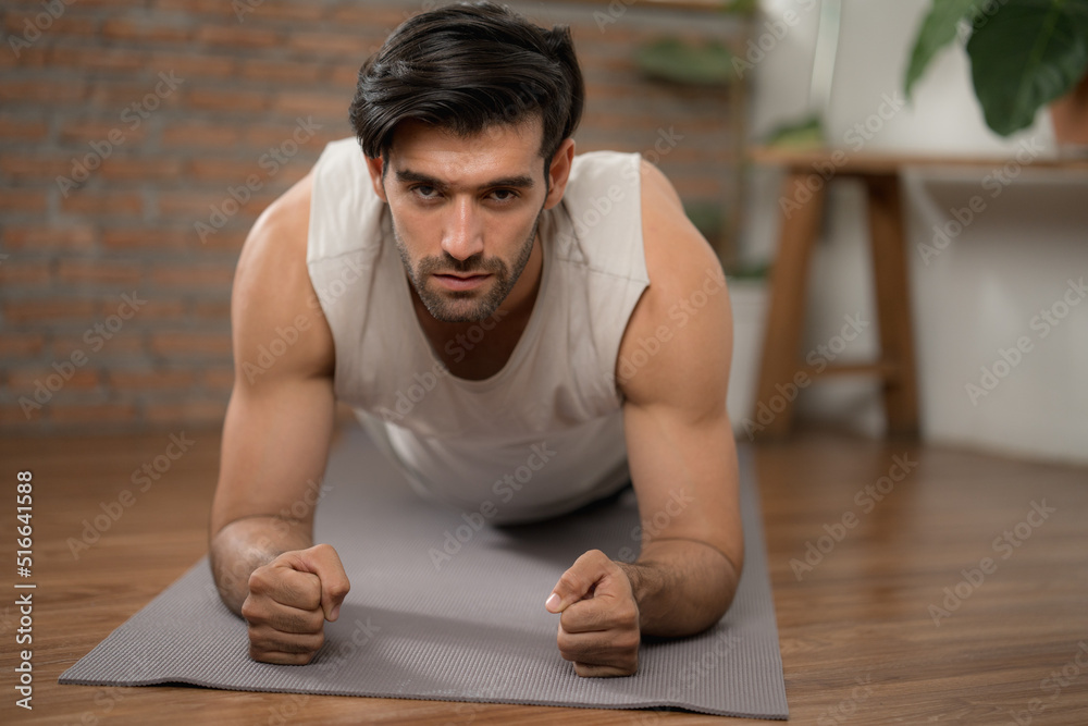 Hansome man with big muscle concentrate on body plank exercise on yoga mat at home gym Hansome man with big muscle concentrate on body plank exercise on yoga mat at home gym