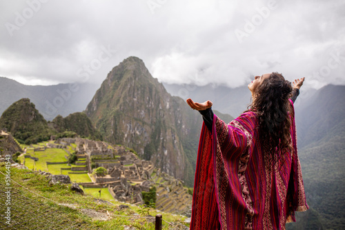 Woman Looking at Inca Citadel called Machupichu built of stones on the mountain, cloudy day, Peru