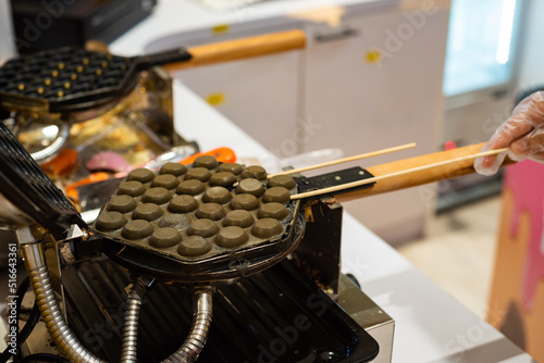 Hong Kong charcoal Waffle is baked on waffle iron machine.
