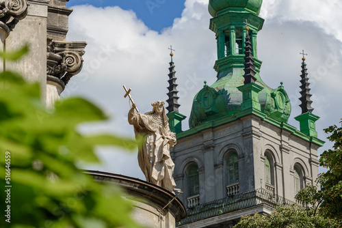 Lviv, Ukraine - june 2022: Figure of the Dominican nun Santa Rosa de Lima, located on the eaves of church of the blessed eucharist (former Dominican church). Korniakta tower on background. photo