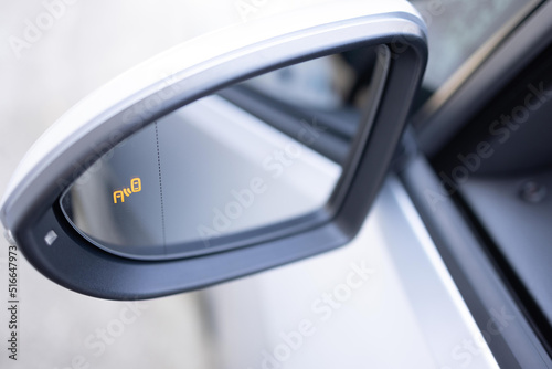 Blind zone monitoring sensor on the side mirror of a modern electric car. System blind spots of the car. Detail of side keeping assist system switch button