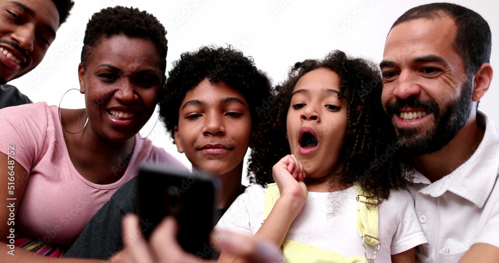 Obraz premium Casual candid family gathered together looking at smartphone